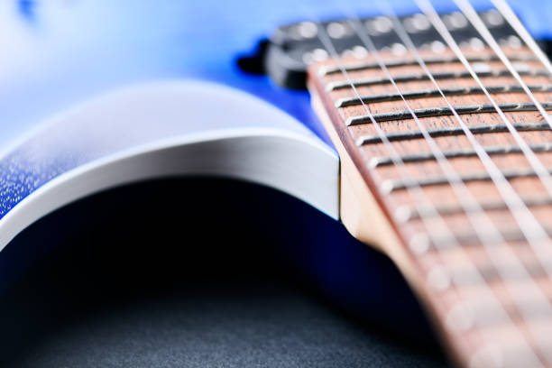 Man plays his guitar on a theater stage with colored lights, smoke around, playing beautiful notes for the audience, in a provided concert and sometimes he performs songs with his beautiful voice