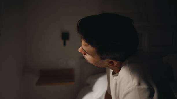 istock Exhausted guy sit alone by bedroom window at night closeup. Tired man insomnia 2176890911