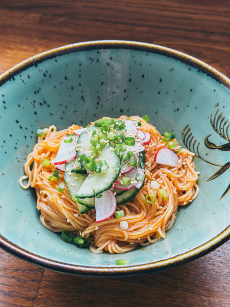 Korean cold noodles dish with fresh vegetables served in Gochujang sauce. The noodle is made with  thin wheat flour noodles called somyeon (소면/素麵)