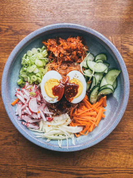 Korean cold noodles dish with fresh vegetables served in Gochujang sauce. The noodle is made with  thin wheat flour noodles called somyeon (소면/素麵)