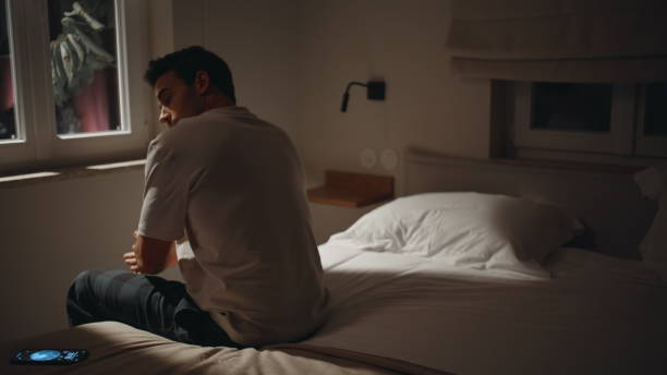 istock Lonely man sitting midnight bedroom with smartphone. Unhappy guy feeling sadness 2176894514