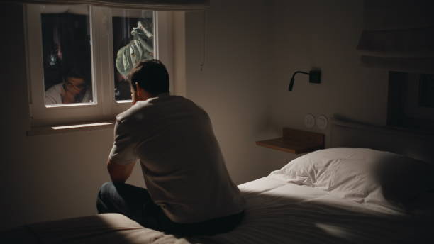 istock Depressed guy sitting bedding by window at night feeling anxious. Pensive man 2176894768