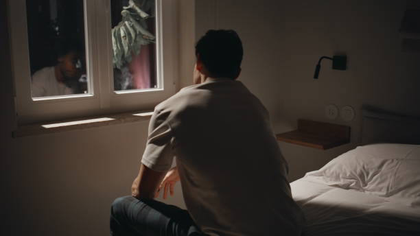 istock Sorrowful man sitting troubled at night bedroom reflected in dark window closeup 2176895376