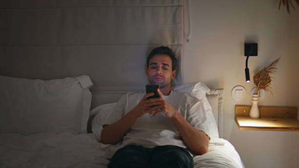 istock Man texting cellphone night bedroom closeup. Male using mobile phone at home bed 2176895953
