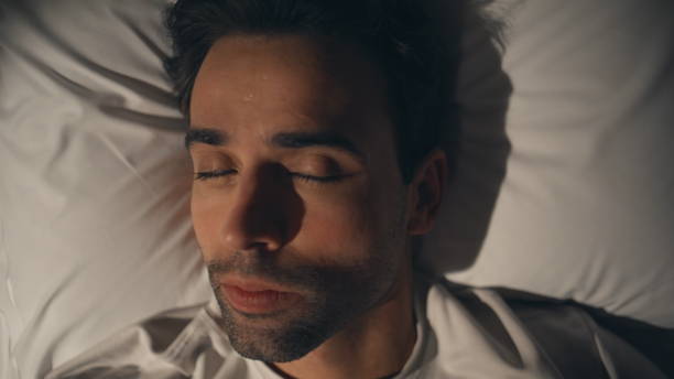 istock Thinking man lying pillow looking up at night closeup. Calm unshaved guy resting 2176896816