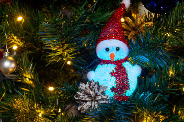 Colored Christmas decorations sparkle merrily on the Christmas tree, creating an atmosphere of magic and festive coziness.