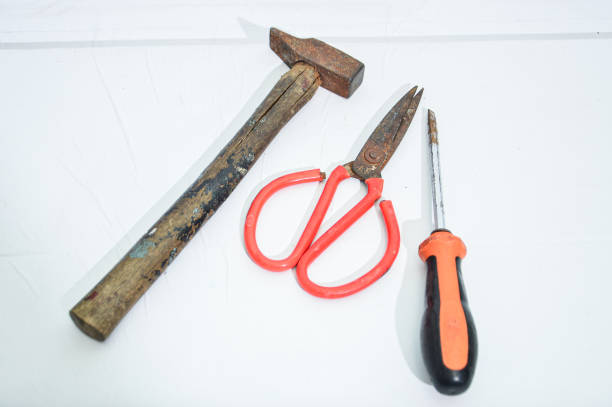 an old scissors, screwdriver and hammer isolated on white