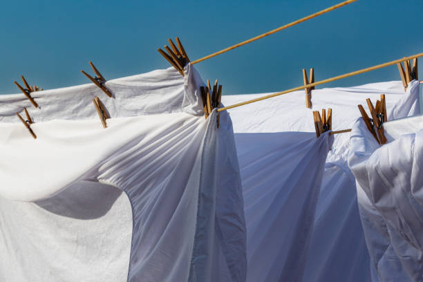 Murcia, Spain - 12th August 2024 - White laundry drying in sunlight against a clear blue sky, creating a vibrant atmosphere during a summer day