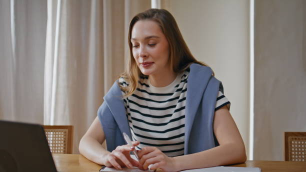 istock Serious girl studying online making notes in copybook at desk home closeup. 2176914883