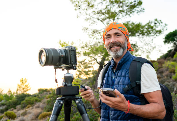 istock Middle-aged photographer or videographer shooting in nature 2176916874