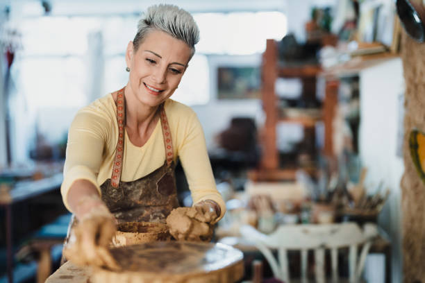 istock Female potter preparing the wheel for a new pot 2176920650