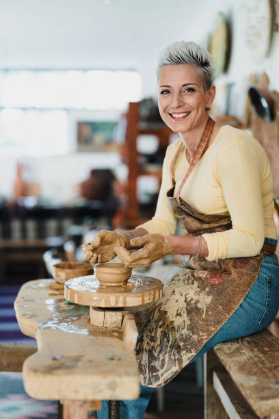 istock Smiling female potter making a clay bowl 2176920656