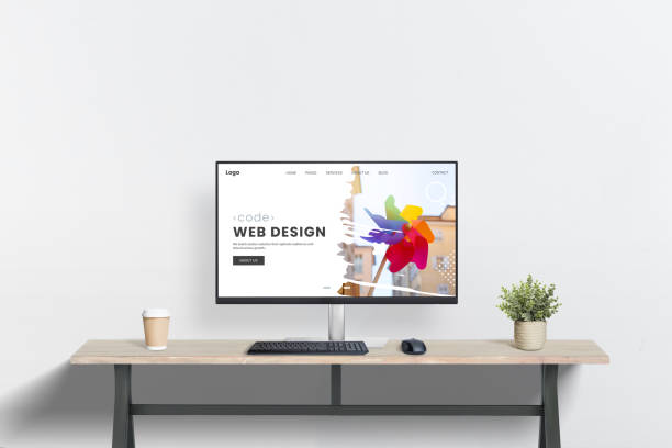 Clean web design workspace with computer display on desk, plant, and coffee mug beside. Minimalist scene ideal for web design studio presentation