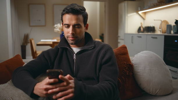 istock Relaxed man using cellphone sitting couch home living room closeup. Focused guy 2176931483