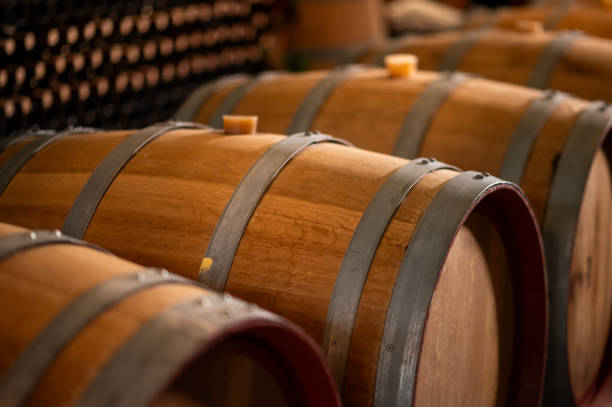 istock Old wooden wine barrels stacked in a cellar in order 2176933335