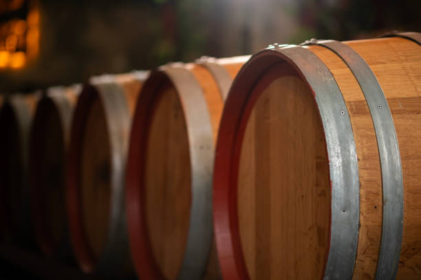 istock Old wooden wine barrels stacked in a cellar in order 2176933356