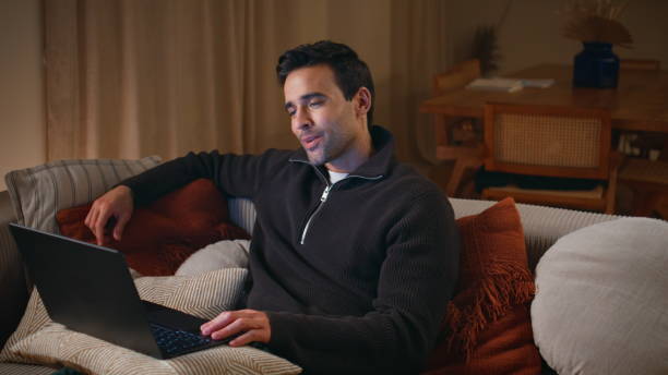 istock Relaxed guy smiling webcam laptop enjoying video call at night home closeup. 2176933398