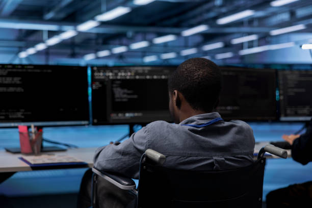istock Man in wheelchair doing tasks in data center 2176936427