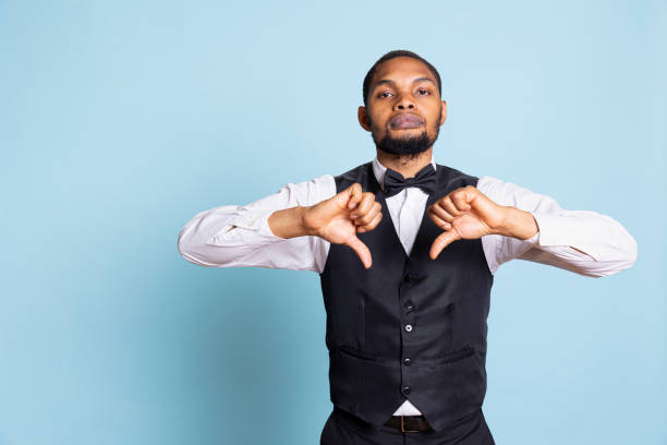 istock Discontent unhappy bellhop gives a thumbs down symbol on camera 2176937080