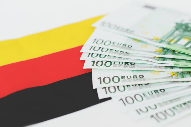 istock flag of germany and several 100 euro banknotes on white background 2176946899