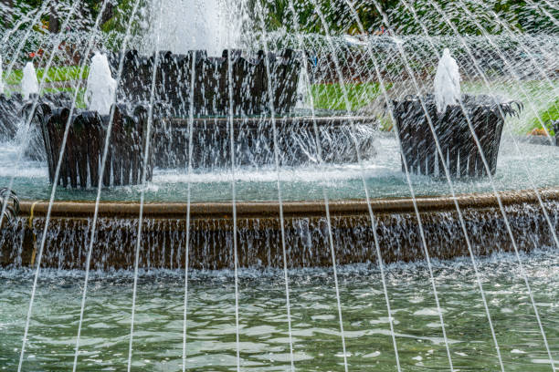 A water fountain in a park with murky, not maintained water.