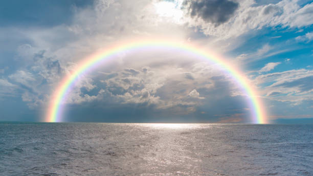 istock Dusk rainbow concept - Beautiful landscape with multi colored calm sea with rainbow at dusk 2176962774