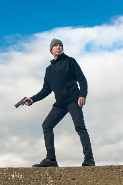 istock Man holding a gun outdoors, bookcover concept 2176967962
