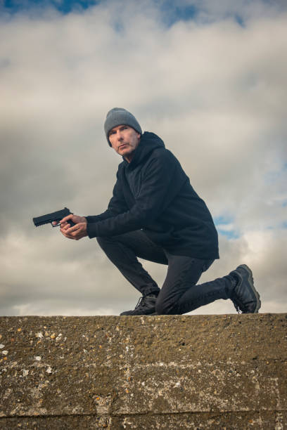 istock Man holding a gun outdoors, bookcover concept 2176967986