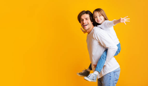 istock Cheerful daddy is holding his happy daughter on his back 2176971311