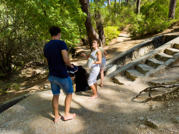 Hiker couple enjoying nature walk up rugged mountain terrain, young people travel for outdoor adventure, active lifestyle, summer leisure activity.