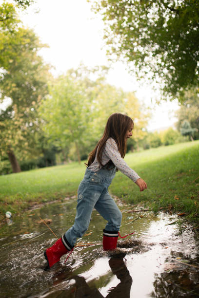 istock Little girl playing in the muddy puddle 2176975990