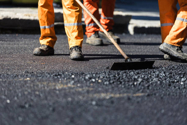 istock Construction workers in bright orange uniforms working diligently to lay asphalt on a city street during the daytime. 2176979061