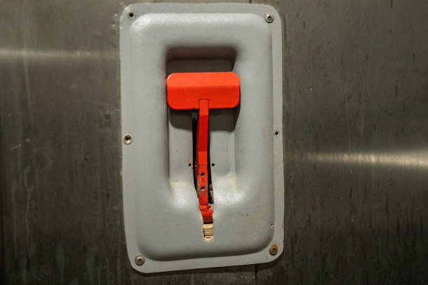 striking red emergency lever stands out against a grimy wall, symbolizing urgency amidst neglect. Its vibrant color contrasts the surrounding decay, evoking a sense of impending action