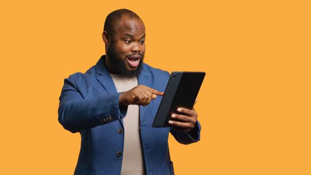 istock Man happily scrolling on tablet touchscreen to check social media 2176979215