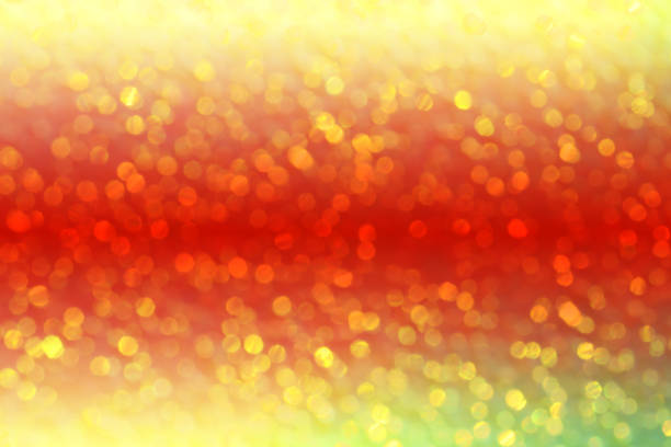 Defocused sparkling background with yellow - red color gradient. Beautiful bokeh lights.