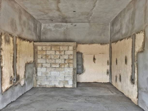 istock Unfinished Room with Exposed Brick and Concrete Walls Under Construction 2176985384