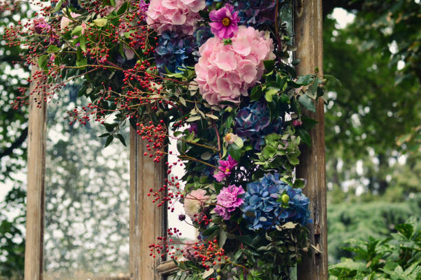 istock Pink, blue hydrangea, red berries, green leaves in decorations on a wooden window 2176986186