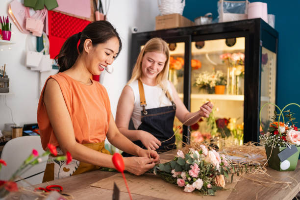 istock Flower Shop Workers Decorating A Bouquet Together 2176992523