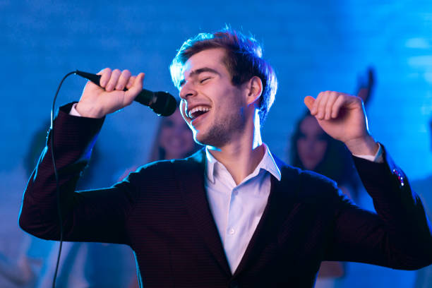 istock Guy Singing Song Holding Microphone At Karaoke Night Party Indoor 2176992636