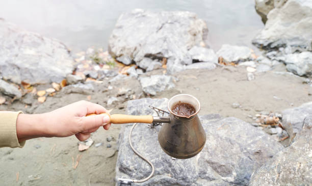 istock Brewing coffee outdoors with a vintage pot by the riverside on a rocky terrain 2176993694