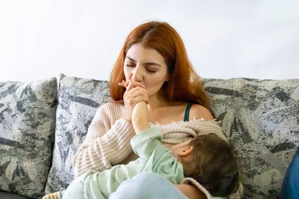 istock Mum breastfeeding and kissing her baby's hand 2176994229