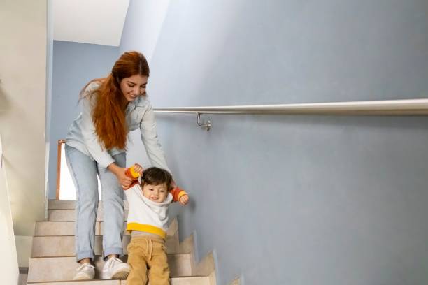 istock Mum taking him down the stairs with her son 2176994579