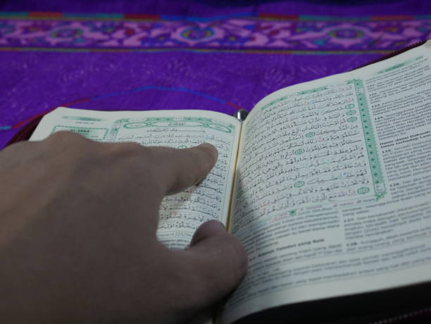 istock Guiding the way: a hand pointing to the Quran, inviting careful reflection and understanding 2177005852