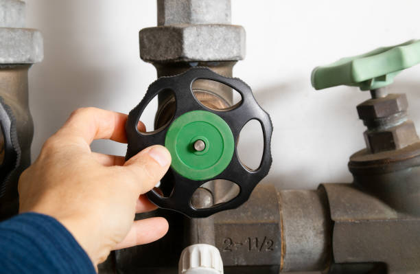 Plumber using backflow shut off valve or backwater valve. Emergency water shut-off preventing contamination of drinking water from sewage backup or bacteria. Selective focus. Lucerne, Switzerland home main water valve stock pictures, royalty-free photos & images