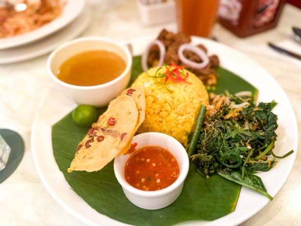istock Yellow rice served with vegetables, beef rendang, soup and chili paste. 2177021252