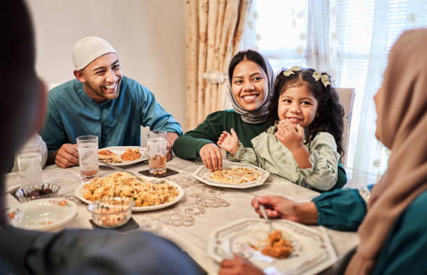 Smiling family enjoying feast together at home for Eid during Ramadan