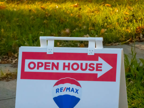 Calgary, Alberta, Canada. Oct 5, 2024. A classic Open House sign featuring the REMAX logo, prominently displayed on a sidewalk in a residential area.