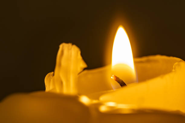 Close-up of a burning candle with a black background
