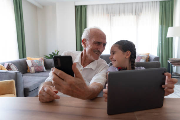 istock Girl and her grandfather using smartphone and digital tablet 2177032719