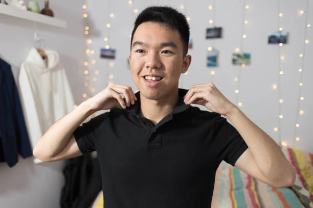 istock Young man adjusting the shirt collar in his bedroom 2177033414